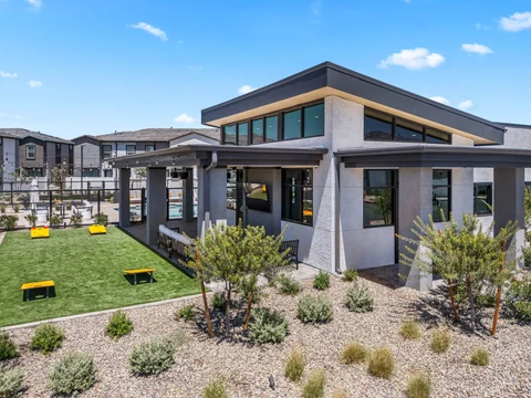 Clubhouse exterior with large windows and a landscaped game lawn