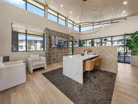 Resident clubhouse with lounge seating and a large gathering table