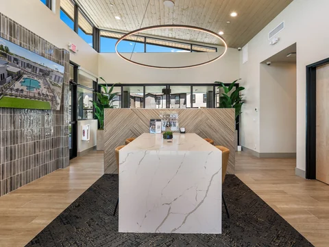 Clubhouse gathering table beneath a ring chandelier and wood ceiling