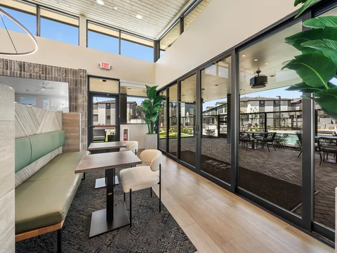 Clubhouse seating beside glass doors opening onto the covered patio