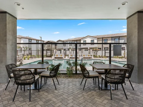 Shaded dining tables overlooking the pool and townhomes