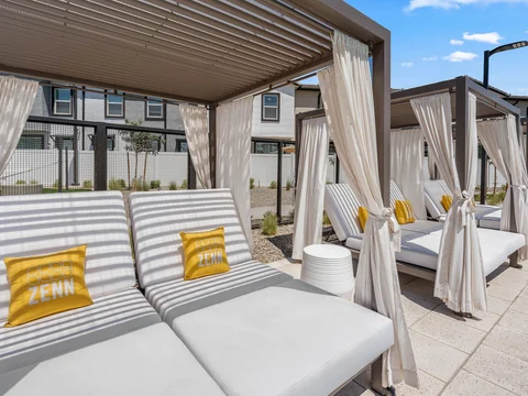 Shaded poolside cabanas with cushioned lounge seating