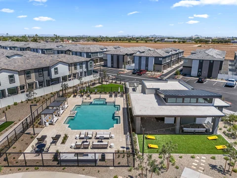 Aerial view of the pool, clubhouse, game lawn, and rows of townhomes