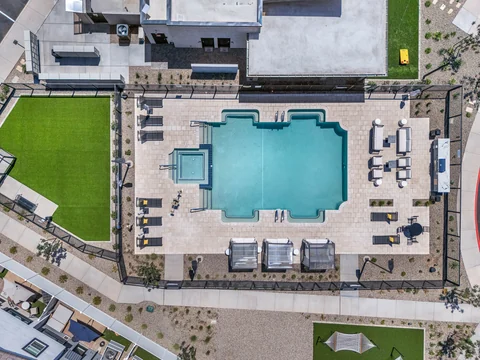Top-down view of the pool, hot tub, cabanas, and lounge chairs
