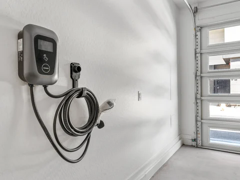 EV charging station mounted beside a townhome garage door