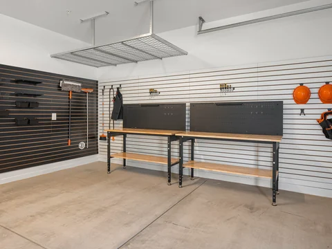 Garage workshop with workbenches, tool storage, and a ceiling-mounted rack