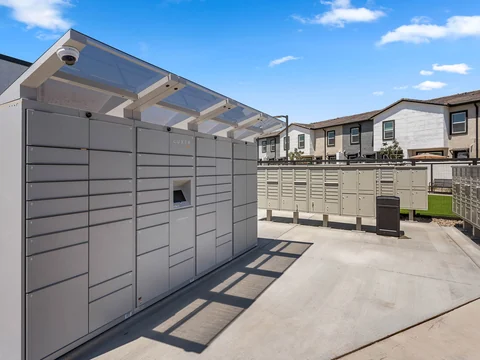Community package lockers beneath a shade canopy