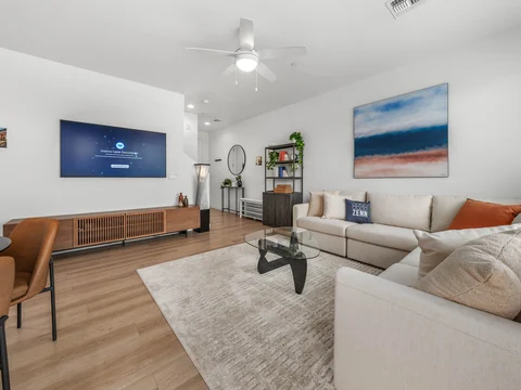 Living room with a sectional sofa, media console, and wall-mounted television