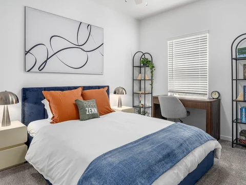 Bedroom with blue accents, a white duvet, and a bookcase