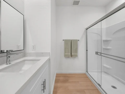 Bathroom with a double-sink vanity and glass-enclosed shower