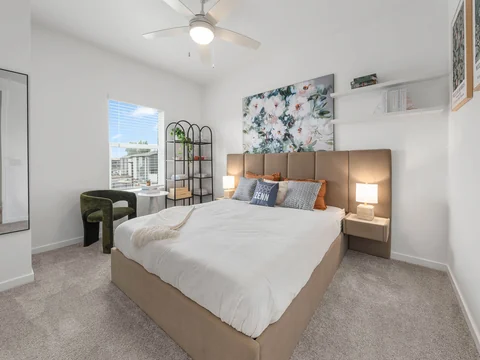Bedroom with a wood headboard, botanical artwork, and a white duvet